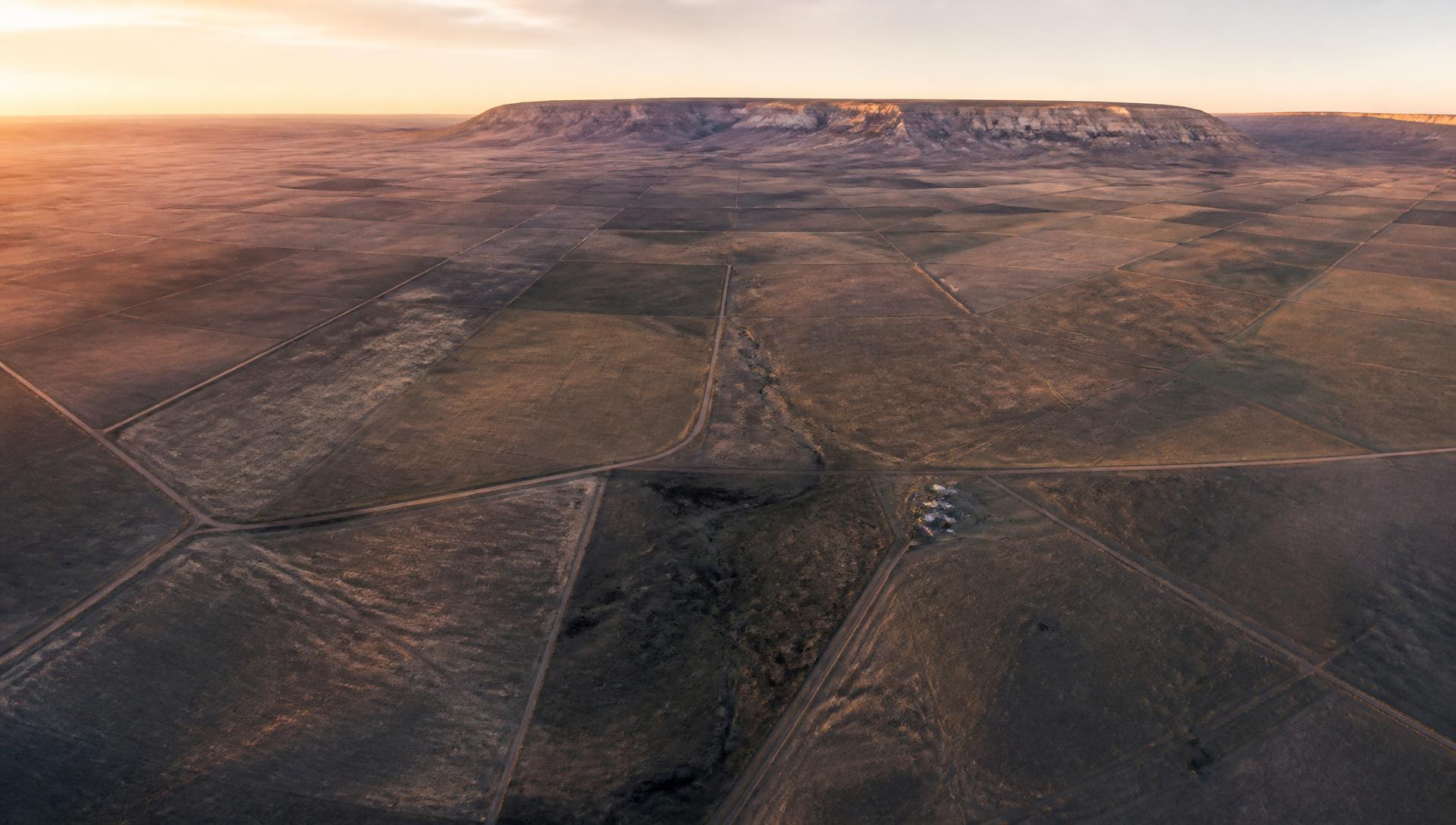 Aerial view of open ranchland divided into surveyed mineral parcels at sunset